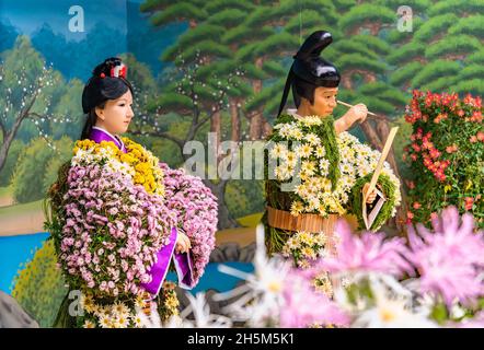 tokio, japan - november 23 2020: Lebensgroße Chrysantheme-Puppen, die eine kaiserliche Hofdame und Ōtomo no Tabito darstellen, deren Gedichte in The man'y zusammengestellt wurden Stockfoto