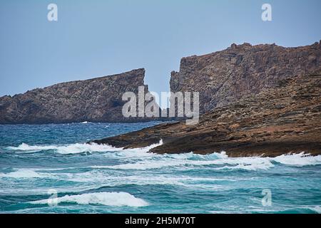 Klippe an der Küste in Form eines Buchstabens v. Mittelmeer, Balearen, türkisfarbenes Wasser, bewegtes Wasser Stockfoto