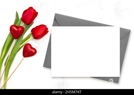 Valentinstag Papierkarte Mockup. Zwei Herzen und rote Tulpenblüten Stockfoto