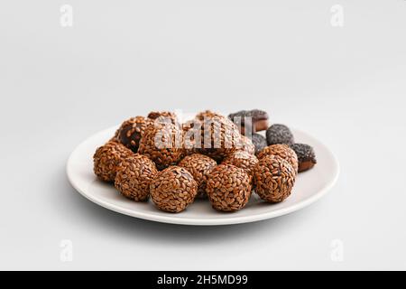 Teller mit leckeren Bonbons aus Leinsamen auf hellem Hintergrund Stockfoto