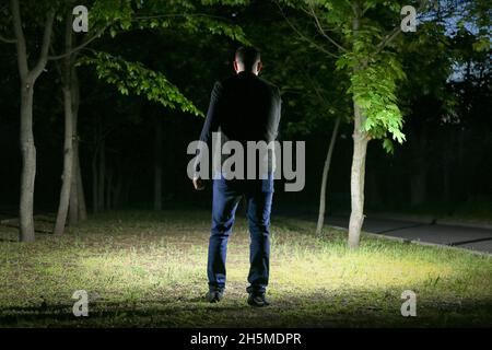 Reifer Mann mit Taschenlampe in der Nacht Stockfoto