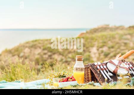 Korbkorb mit leckerem Essen und Getränk für Picknick in den Bergen Stockfoto