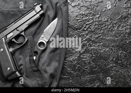 Klapptaschenmesser mit Pistole auf schwarzem Hintergrund Stockfoto