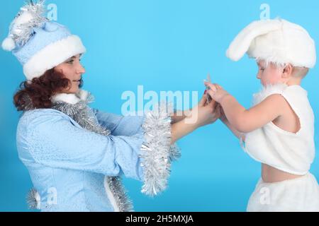 Junge Frau mit kleinem Baby in Neujahrskostümen Stockfoto