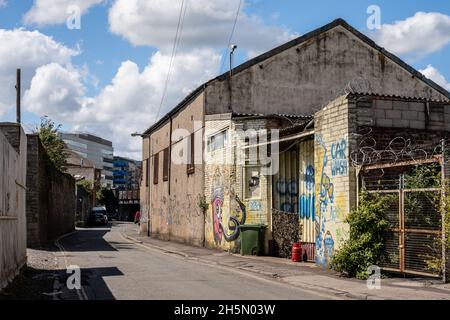 Heruntergekommenen und verkommenen leichten Industriegebäuden entlang der Gas Lane, die Teil eines städtischen Sanierungsgebiets in Bristol ist, mit modernen Bürogebäuden der TEM Stockfoto