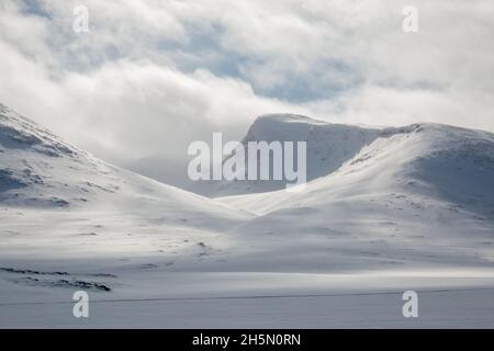 Die Berge rund um den Kungsleden-Pfad sind schneebedeckt in der Nähe der Tjaktja-Hütte bei Sonnenaufgang im April 2021, Lappland, Schweden Stockfoto