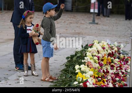 Arlington, Usa. November 2021. Harper Tomlinson, 5, beobachtet ihren Bruder Davis Tomlinson, 7, beim Gruß, nachdem sie Blumen während einer hundertjährigen Gedenkveranstaltung am Grab des unbekannten Soldaten auf dem Nationalfriedhof von Arlington, Mittwoch, den 10. November 2021, in Arlington, Virginia. Pool Foto von Alex Brandon/UPI Kredit: UPI/Alamy Live News Stockfoto