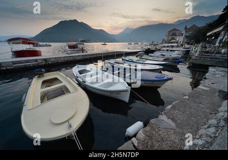 Perast, Montenegro, 7. September 2019: An einem Sommerabend, wenn die Dämmerung nachlässt, ruhen die Boote friedlich auf den ruhigen Gewässern der Bucht von Kotor. Stockfoto