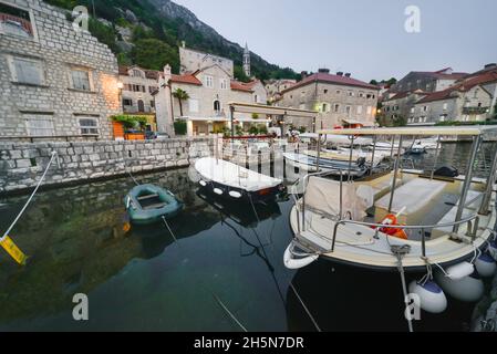 Perast, Montenegro, 7. September 2019: An einem Sommerabend, wenn die Dämmerung nachlässt, ruhen die Boote friedlich auf den ruhigen Gewässern der Bucht von Kotor. Stockfoto