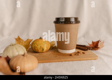 Kaffee Take Away Tasse im Herbst Kürbis aufgestellt. Kürbis-Latte mit Schlagsahne und frischem Zimt würzen. Kaffee zum trinken Stockfoto