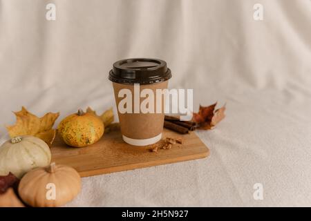 Kaffee Take Away Tasse im Herbst Kürbis aufgestellt. Kürbis-Latte mit Schlagsahne und frischem Zimt würzen. Kaffee zum trinken Stockfoto