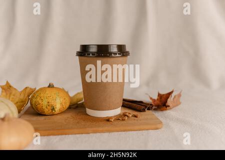 Kaffee Take Away Tasse im Herbst Kürbis aufgestellt. Kürbis-Latte mit Schlagsahne und frischem Zimt würzen. Kaffee zum trinken Stockfoto