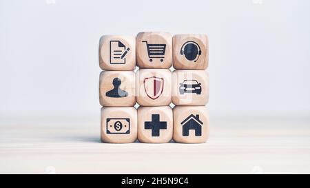 Konzept der verschiedenen Arten von Versicherungsgeschäft. Holzwürfel mit Auto, Geld, Gesundheit, Unterstützung, Immobilien-Ikonen Stockfoto