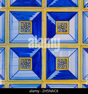 Fragment der Gebäudewand mit bunten keramischen Wandfliesen. Abstrakt dekorativer Hintergrund. Azulejos, traditionelle, reich verzierte portugiesische Architektur. Stockfoto