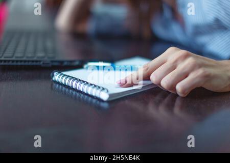 Frau zeigte auf ein leeres Notizbuch auf dem Schreibtisch in Nahaufnahme Stockfoto