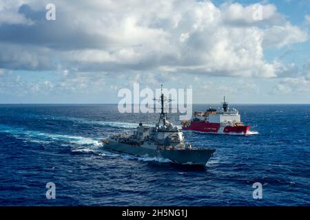 ATLANTISCHER OZEAN (Okt 26, 2021) der polare Eisbrecher USCGC Healy (WAGB 20) und der Arleigh Burke-Klasse-Lenkungszerstörer USS Jason Dunham (DDG 109) führen eine bestandende Übung durch. Healy umrundet Nordamerika nach einem Transit durch die Nordwestpassage und unterstützt die wissenschaftliche Forschung in der Arktis. Jason Dunham ist im Atlantischen Ozean tätig, um Marinestützungen zu unterstützen, um die maritime Stabilität und Sicherheit zu wahren, um den Zugang zu gewährleisten, Aggressionen abzuwehren und die Interessen der USA, der Alliierten und der Partner zu verteidigen. (USA Navy Foto von Mass Communication Specialist Seaman Theoplis Stewart II/Rele Stockfoto