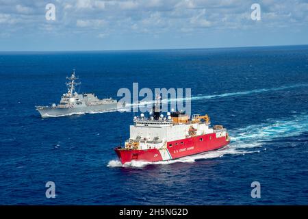 ATLANTISCHER OZEAN (Okt 26, 2021) der polare Eisbrecher USCGC Healy (WAGB 20) und der Arleigh Burke-Klasse-Lenkungszerstörer USS Jason Dunham (DDG 109) führen eine bestandende Übung durch. Der Einsatz von Healy zeigt das Engagement der USA für eine sichere und sichere Arktis, da die Schneidcrew viereinhalb Monate lang eingesetzt wird, um operative Eistests durchzuführen, die Beziehungen zu Partnerländern zu stärken, die US-Präsenz zu projizieren und die Rechte der US-Souveränität zu schützen. Jason Dunham ist im Atlantischen Ozean tätig, um Marineinoperationen zu unterstützen, um die maritime Stabilität und Sicherheit für ENS zu gewährleisten Stockfoto