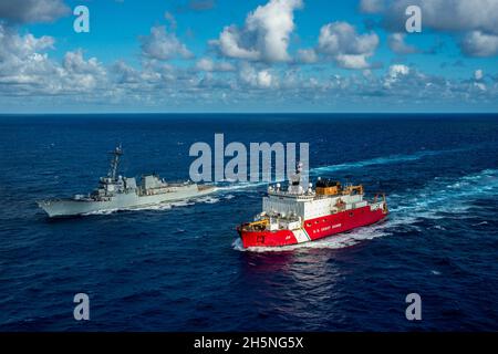 ATLANTISCHER OZEAN (Okt 26, 2021) der polare Eisbrecher USCGC Healy (WAGB 20) und der Arleigh Burke-Klasse-Lenkungszerstörer USS Jason Dunham (DDG 109) führen eine bestandende Übung durch. Der Einsatz von Healy zeigt das Engagement der USA für eine sichere und sichere Arktis, da die Schneidcrew viereinhalb Monate lang eingesetzt wird, um operative Eistests durchzuführen, die Beziehungen zu Partnerländern zu stärken, die US-Präsenz zu projizieren und die Rechte der US-Souveränität zu schützen. Jason Dunham ist im Atlantischen Ozean tätig, um Marineinoperationen zu unterstützen, um die maritime Stabilität und Sicherheit für ENS zu gewährleisten Stockfoto