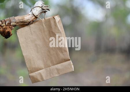 Papiertüte inmitten von Bäumen in der Natur. Stockfoto