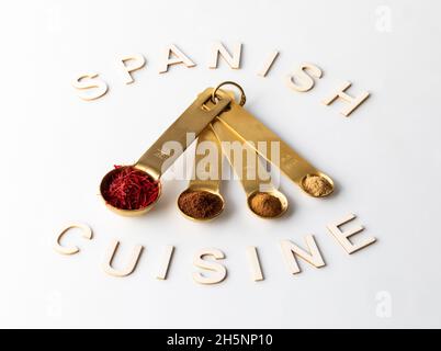 Messlöffel gefüllt mit verschiedenen Gewürzen, die in der spanischen Küche verwendet werden. Stockfoto
