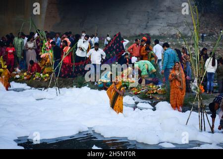 Okhla, Indien. November 2021. Anhänger sahen den sonnengott anbeten, während sie inmitten der giftigen Schaumstoffe stehen, die den Yamuna-Fluss während des hinduistischen religiösen Festivals bedecken.Chhath Puja ist der Sonnengottheit und Shashthi Devi (Chhathi Maiya) gewidmet. Sie für die Erfolge des Lebens auf der Erde zu danken und um bestimmte Wünsche zu erbitten. Dieses Fest wird von Biharis zusammen mit ihrer Diaspora gefeiert. Kredit: SOPA Images Limited/Alamy Live Nachrichten Stockfoto