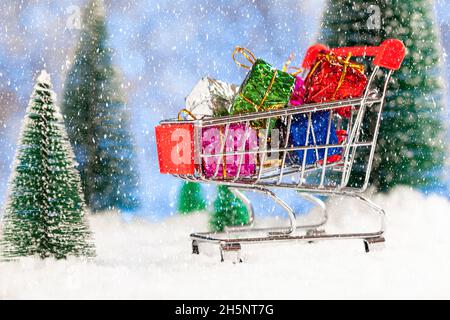 Weihnachtseinkäufe. Supermarkt-Trolley mit Neujahrsgeschenken. Grußkarte zum neuen Jahr Stockfoto