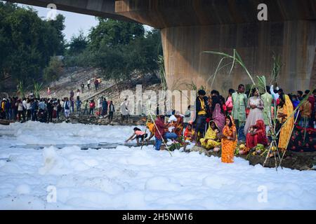 Okhla, Indien. November 2021. Eine eifrige Anhängerin sah den sonnengott anbeten, als sie inmitten der giftigen Schaumstoffe steht, die den Yamuna-Fluss während des hinduistischen religiösen Festivals bedecken.Chhath Puja ist der Sonnengottheit und Shashthi Devi (Chhathi Maiya) gewidmet. Sie für die Erfolge des Lebens auf der Erde zu danken und um bestimmte Wünsche zu erbitten. Dieses Fest wird von Biharis zusammen mit ihrer Diaspora gefeiert. (Foto von Manish Rajput/SOPA Images/Sipa USA) Quelle: SIPA USA/Alamy Live News Stockfoto