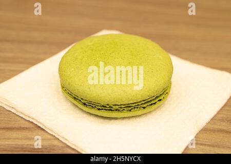 Makkaroni-Kekse in verschiedenen Farben auf einer weißen Serviette auf einem Holztisch Stockfoto