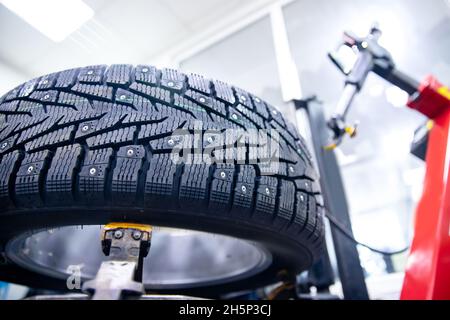 Nahaufnahme Winterreifen mit Stahlbolzen im Einsatz auf der Werkzeugmaschine. Stockfoto