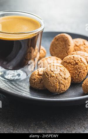 Amaretti-Kekse. Süße italienische Mandelkekse und Kaffeetasse auf Küchentisch. Stockfoto