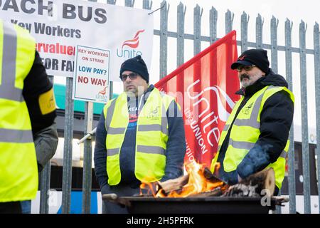 Stockton-on-Tees, Großbritannien. November 2021. Streikende Busfahrer stehen während des Streiks vor einem Feuer auf einer Streiklinie vor dem Haupttor ihres Busdepots.erster Tag der Busfahrer für Stagecoach North East Streikaktion in Stockton nach Gesprächen zwischen Unite the Union und dem Unternehmen brach zusammen. In Stockton-on-Tees und Hartlepool wurden Streiks abgehalten, nachdem die Gewerkschaft sagte, dass die Mitarbeiter weniger bezahlt wurden als die Kollegen in anderen Teilen der Region. (Bild: © Jason Brown/SOPA Images via ZUMA Press Wire) Stockfoto