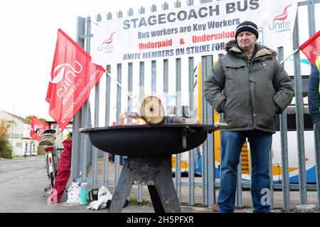 Stockton-on-Tees, Großbritannien. November 2021. Ein streikender Busfahrer steht während des Streiks neben einem Brand auf einer Streikschnur.erster Tag der Busfahrer für die Streikaktion von Stagecoach North East in Stockton, nachdem Gespräche zwischen Unite the Union und dem Unternehmen zusammenbrachen. In Stockton-on-Tees und Hartlepool wurden Streiks abgehalten, nachdem die Gewerkschaft sagte, dass die Mitarbeiter weniger bezahlt wurden als die Kollegen in anderen Teilen der Region. (Bild: © Jason Brown/SOPA Images via ZUMA Press Wire) Stockfoto