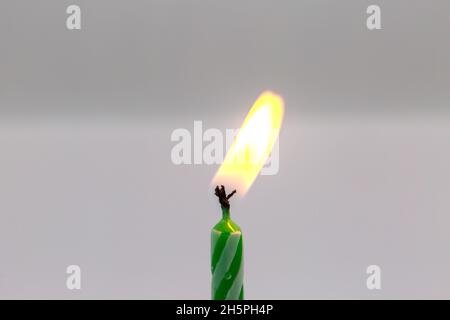 Grüne Geburtstagskerze auf weißem Hintergrund Stockfoto