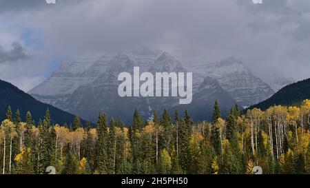 Schöner Blick auf den wolkenbedeckten Mount Robson (3.954 m) mit schneebedecktem Gipfel in den Rocky Mountains in British Columbia, Kanada mit bunten Bäumen. Stockfoto