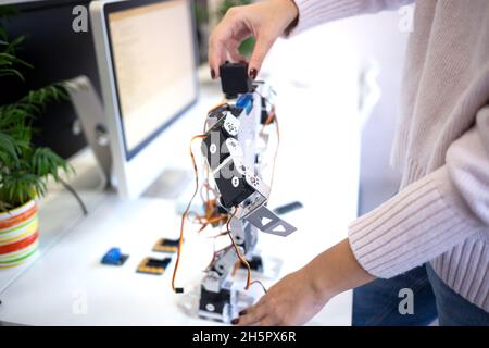 Nahaufnahme. Frau entwirft einen großen modernen Roboter. Stockfoto