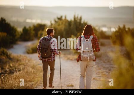 Porträt eines glücklichen jungen Paares, das Spaß auf ihrem Wanderausflug hat. Kaukasisches und asiatisches Wanderpaar, das sich im Sommerurlaub amüsieren kann. Junge Menschen wandern in der Natur. Stockfoto
