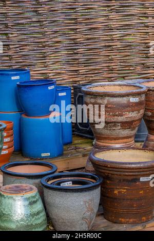 Keramik-Töpfe in einem Gartencenter, farbige Pflanzentöpfe zum Verkauf ein Gartengeschäft, Gärtner Wunden Verkauf von Pflanzentöpfen, Gartenzubehör, Gartendekor. Stockfoto