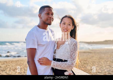 Porträt eines glücklichen jungen schönen Paares am Strand Stockfoto
