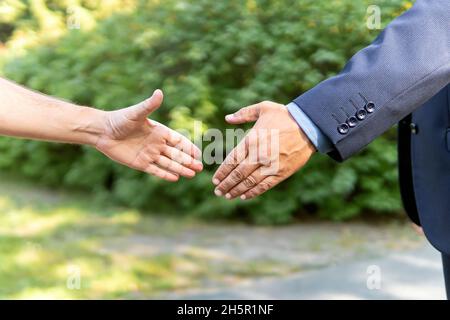 Bauer Und Geschäftsmann Schütteln Die Hände. Begrüßung des Handshakes aus der Nähe auf dem Hintergrund des Parks. Treffen mit Freunden in der Natur. Geschäftsmann und Mitarbeiter. Stockfoto