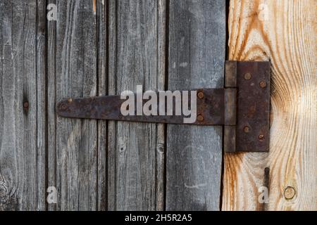 Türscharnier aus rostigem Metall. Türscharnier an einer Holzwand. Stockfoto