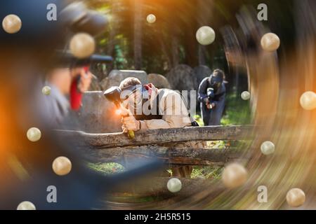 Männer und Frauen spielen Paintball Stockfoto