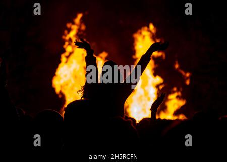 Eine unkenntlich silhouettierte Frau vor einem Lagerfeuer Stockfoto
