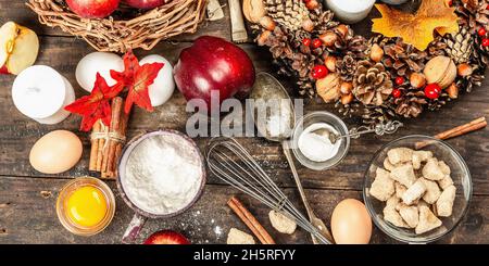 Herbstbackkonzept. Küchenausstattung, Set mit Zutaten, saisonale Einrichtung. Kochen süßes Gebäck mit Äpfeln und Gewürzen. Alter Holzhintergrund, oben Stockfoto