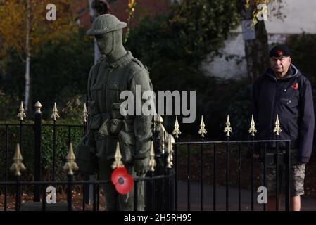 Syston, Leicestershire, Großbritannien. November 2021. Ein Veteran betrachtet einen lebensgroßen gestrickten Soldaten während der gedenkfeiern zum Waffenstillstandstag im Syston war Memorial. Credit Darren Staples/Alamy Live News. Stockfoto