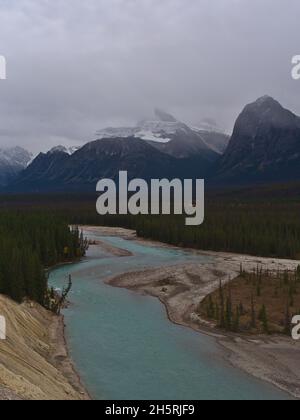 Atemberaubender Blick über den wilden Athabasca River im Jasper National Park, Alberta, Kanada, umgeben von dichten Nadelwäldern mit den Rocky Mounints. Stockfoto