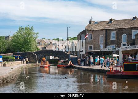 Canal UK, Blick im Sommer auf ein Schmalboot, das in Richtung Springs Branch Canal im historischen Zentrum von Skipton, North Yorkshire, England, Großbritannien, fährt Stockfoto