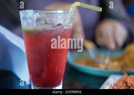 Granatapfelsaft in einem großen Glas auf dem Tisch Stockfoto