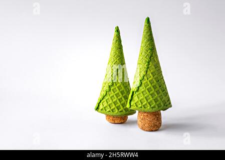 Zwei Weihnachtsbäume aus Waffelkegel und Sektkorken auf weißem Hintergrund. Stockfoto