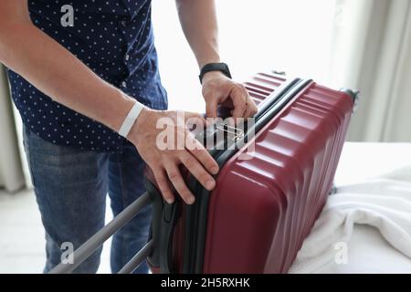Mann schließt Koffer mit Zahlenschloss aus der Nähe zu Hause Stockfoto