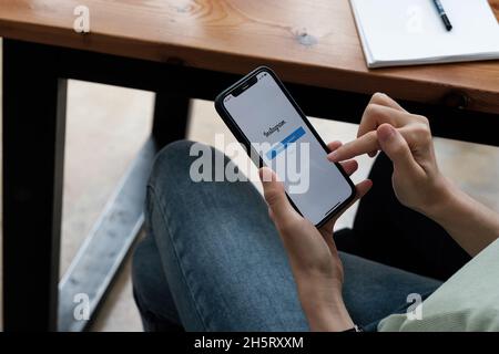 CHIANG MAI, THAILAND - SEP 05 2021: Eine Frau hält Apple iPhone 6s mit Instagram-Anwendung auf dem Bildschirm im Café. Instagram ist eine App zum Teilen von Fotos Stockfoto